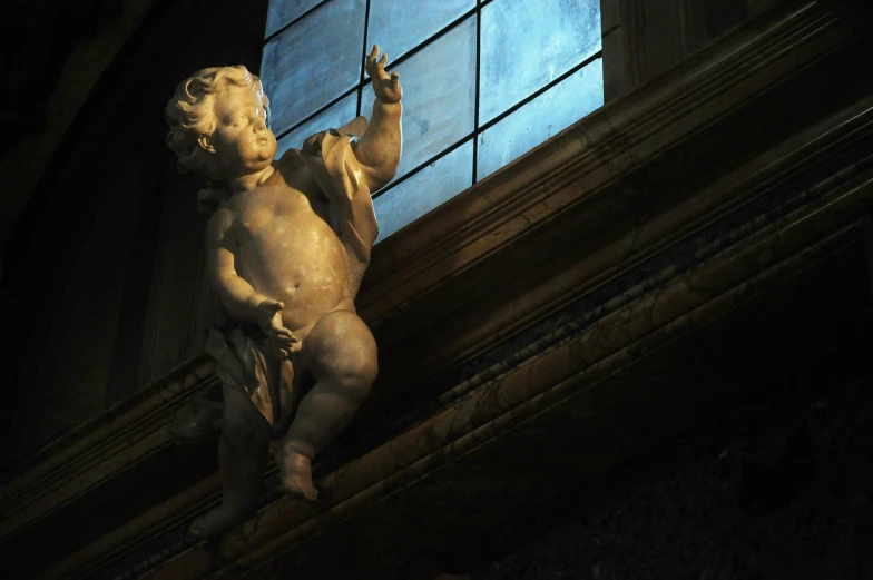 a statue standing next to a window with a blue sky