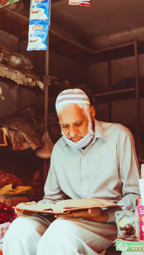 a man reads through a book in his shop