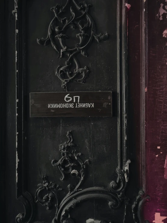 an ornamental wooden door with writing above the door