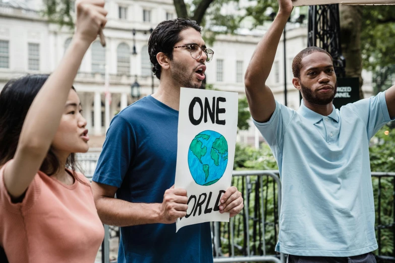 two protesters hold signs with the same image of the earth