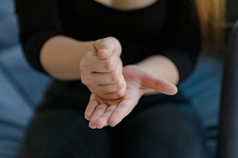 the woman is gesturing at the camera while holding her hands out