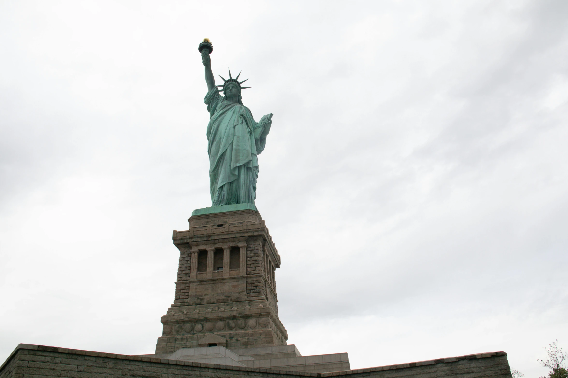 the statue of liberty is tall on a cloudy day