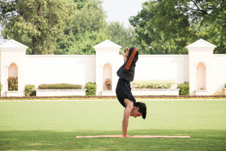 man performing hand stand in the park