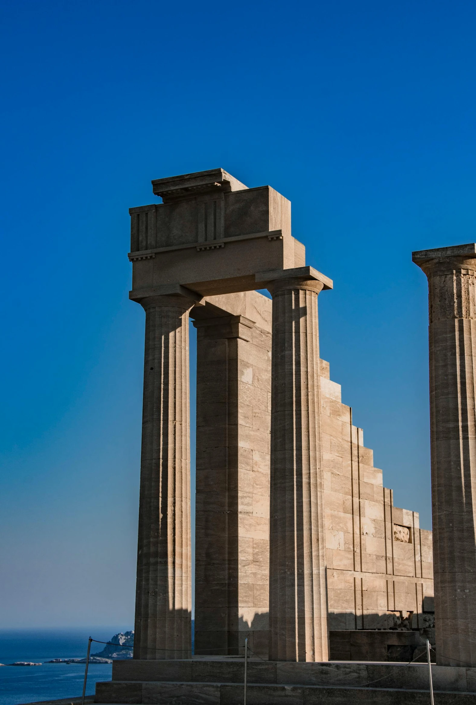 an unusual ancient structure with massive pillars stands against a blue sky