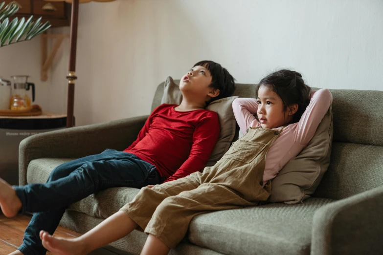 two children are on a couch facing one another