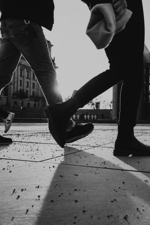 two people are skating along the concrete pavement