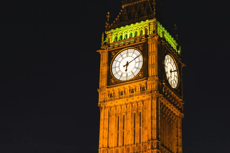 big ben is illuminated in the dark with yellow light