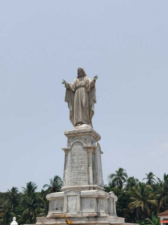 the statue of jesus is located near the palm trees