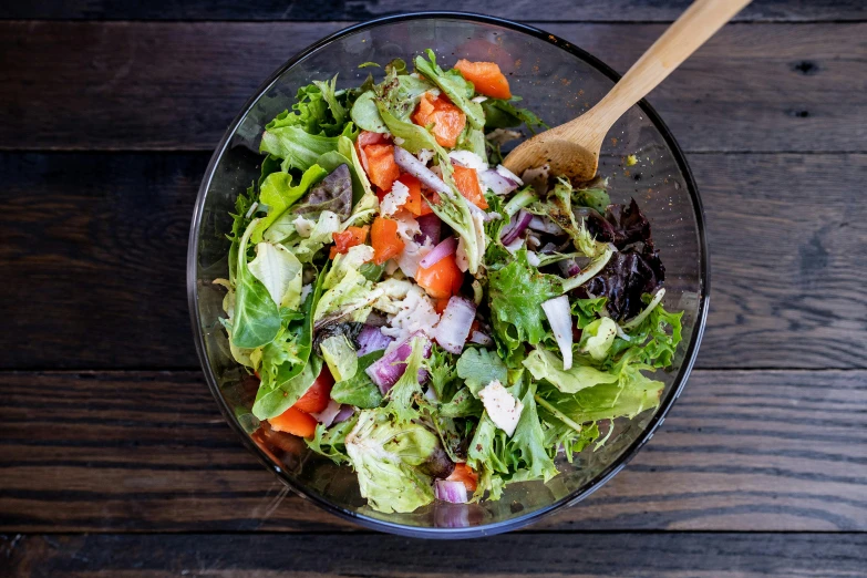 a fresh salad with carrots, onions and lettuce