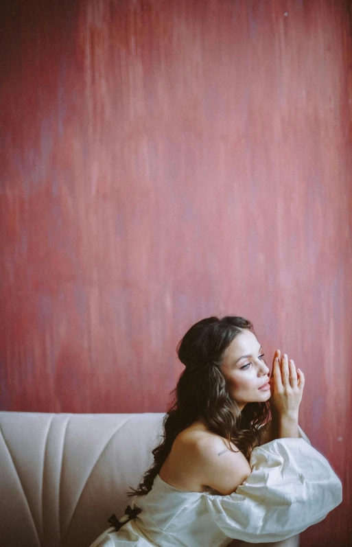 a woman is sitting on the couch posing for the camera