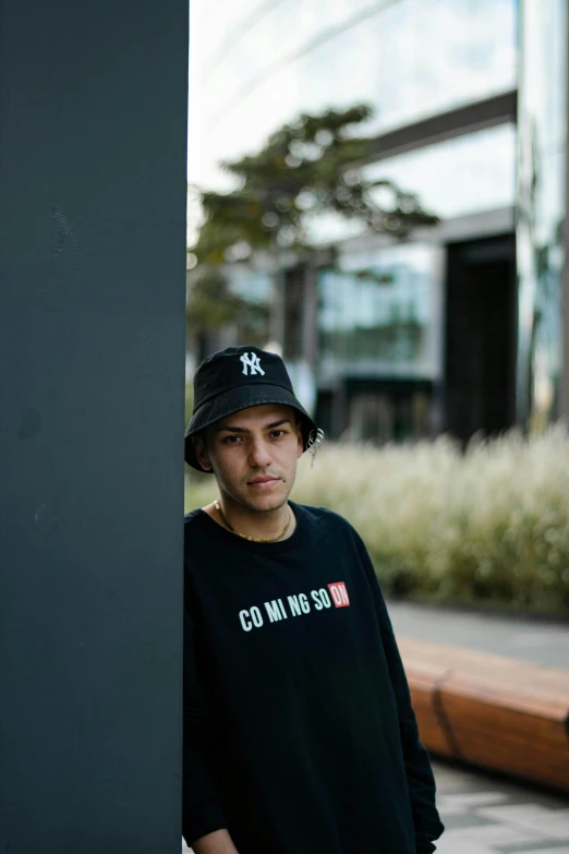 a man standing next to a pole wearing a cap