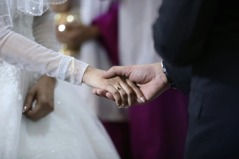 two people holding hands in front of other people