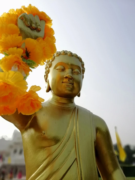 the buddha statue holding three flowers on his right hand