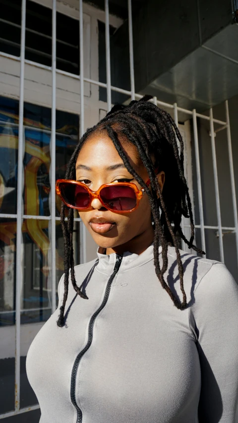 a woman with sunglasses on in front of a window