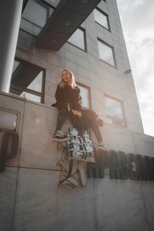 woman sitting on the side of a building near the window with the word philadelphia