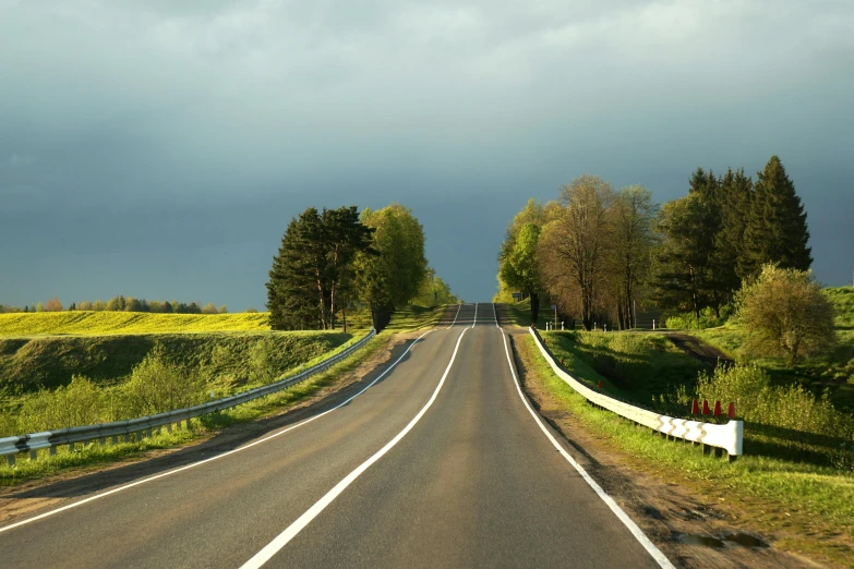 two lane road with a field and grassy pasture in the background