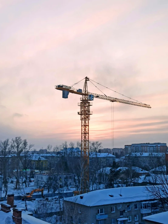 a tower crane is standing on top of a snowy hill