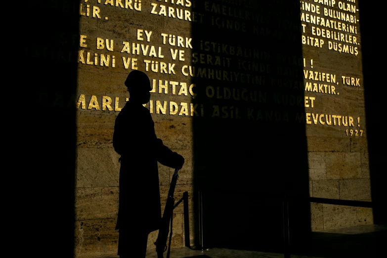 shadow of a man holding a cane in front of a sign