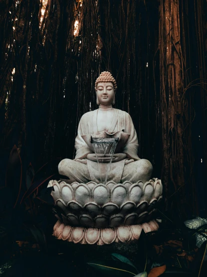 a buddha statue is in a forest of tall trees