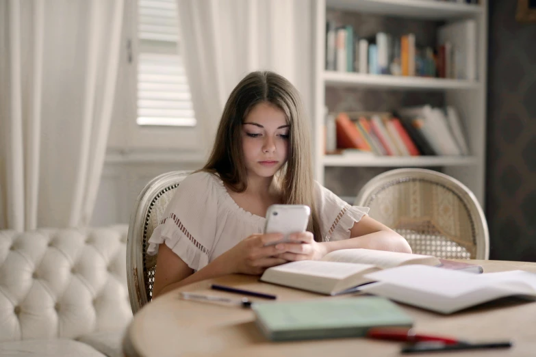 a woman uses her phone and stares down at the screen