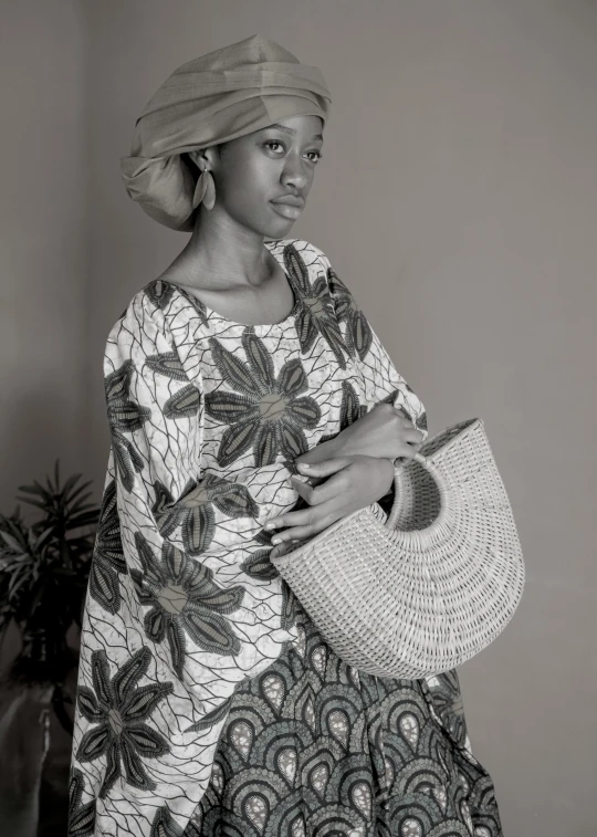 a woman in a african ethnic dress holding a white bag