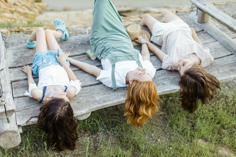 s are laying on a park bench on a beach