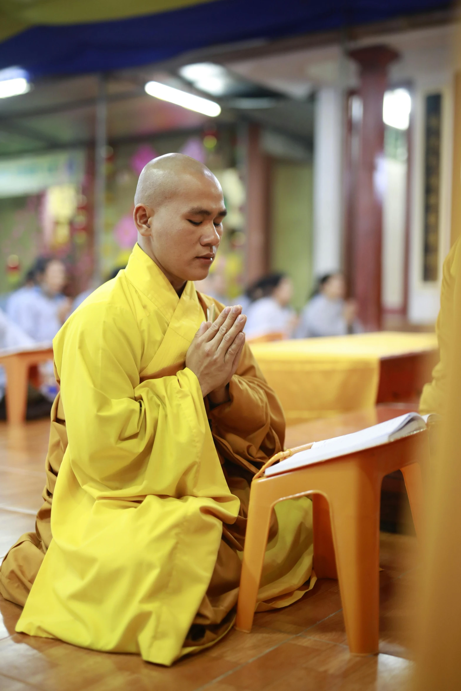 a man sitting down with his hands together