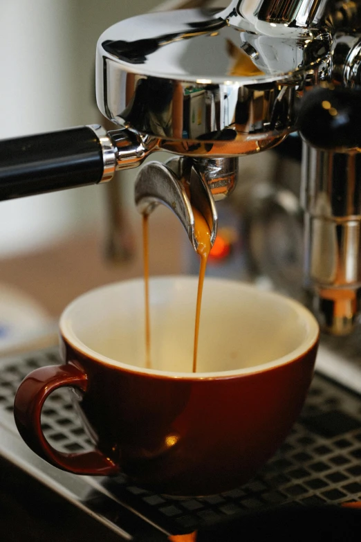 a coffee machine pouring espresso coffee into a cup