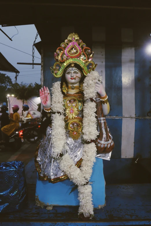 a statue is wearing an elaborate headdress and a gold veil