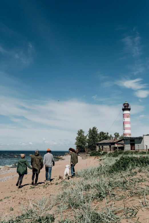 a group of people are walking on the beach