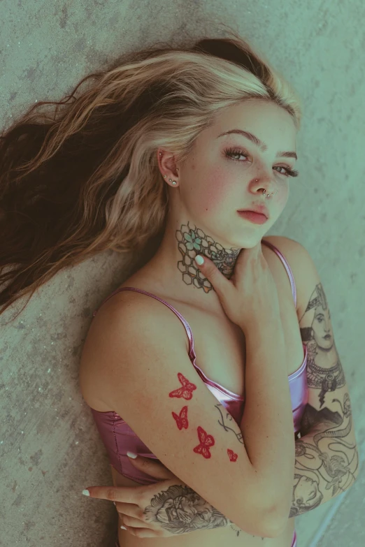 young woman posing for a picture with tattoos on her arms