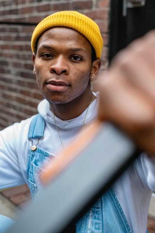 man with hat in motion holding up a camera