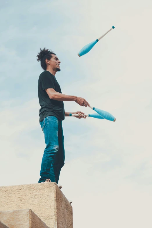 the man is holding two umbrellas while standing on top of the roof