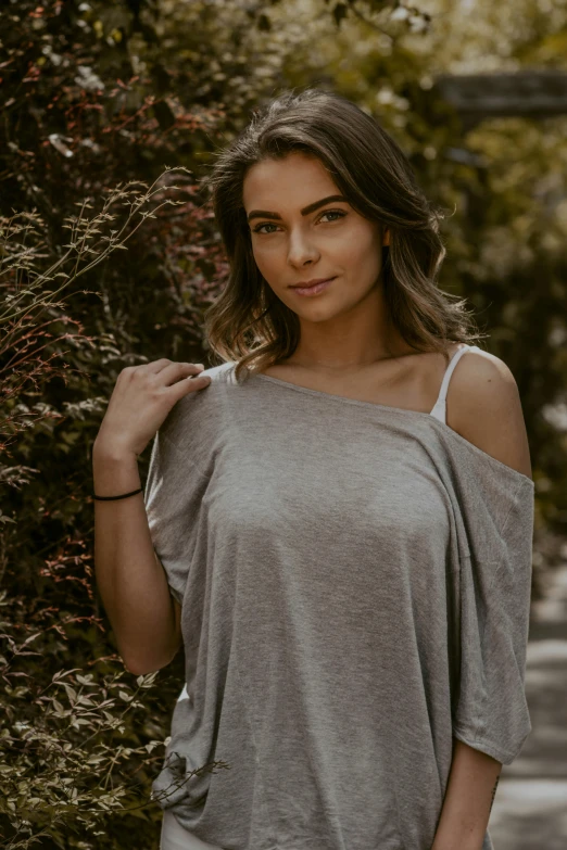 a young woman wearing a t - shirt while posing for a picture