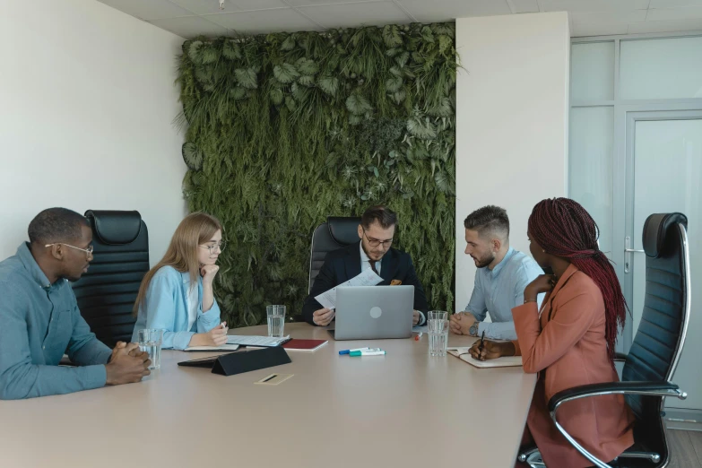 a group of business people sitting around a table together