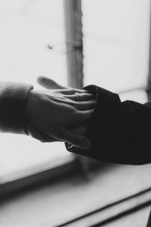 black and white pograph of someones hand reaching out of a window