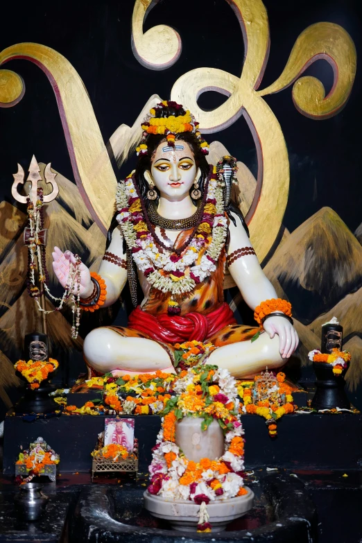 a statue of hindu deities, sitting at a altar