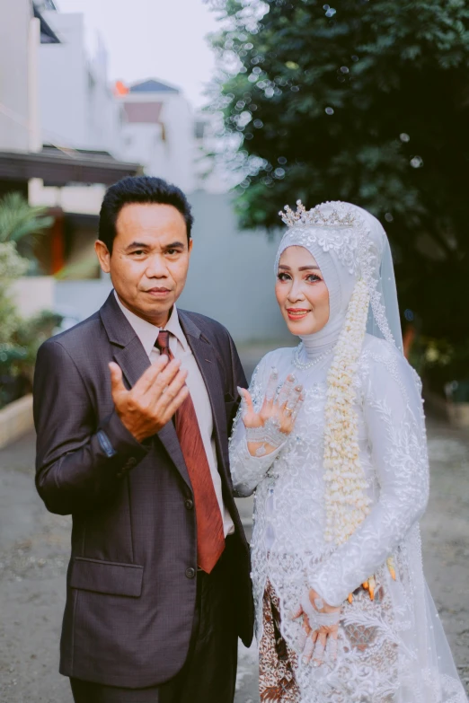 an asian couple posing for a picture in front of some buildings