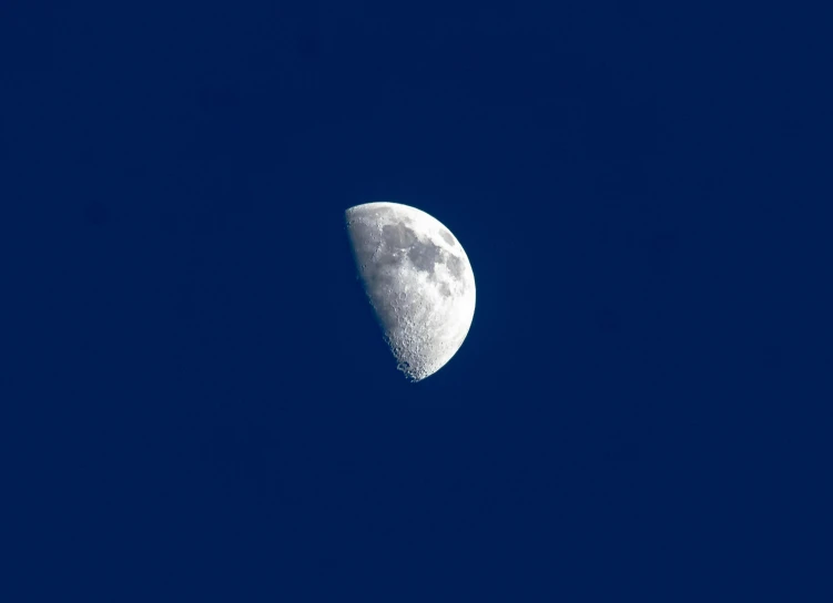 half moon in a dark blue sky with a bright side