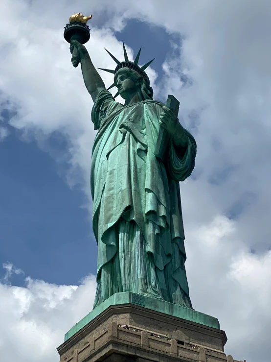 the statue of liberty looks upward with its hand on the tip