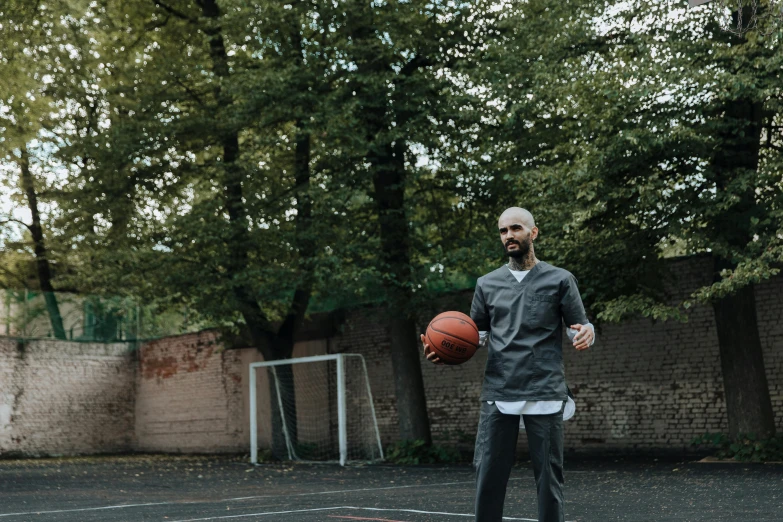 an older man is holding a basketball and practicing on the court