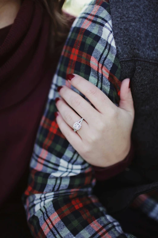 a close up of a woman wearing a engagement ring