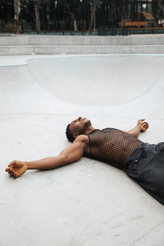 a person laying on the ground next to a skate board ramp