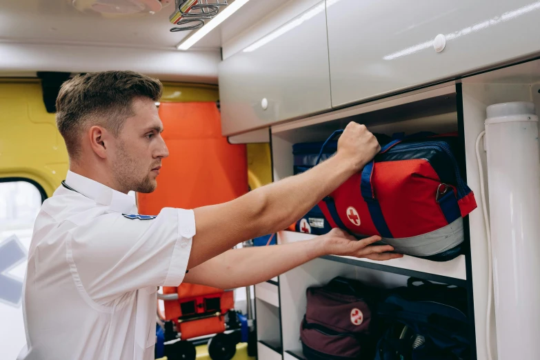 a man looking through locker of his boat, with backpacks on it