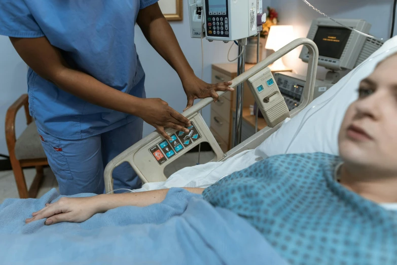 a woman in a hospital bed holding a monitor