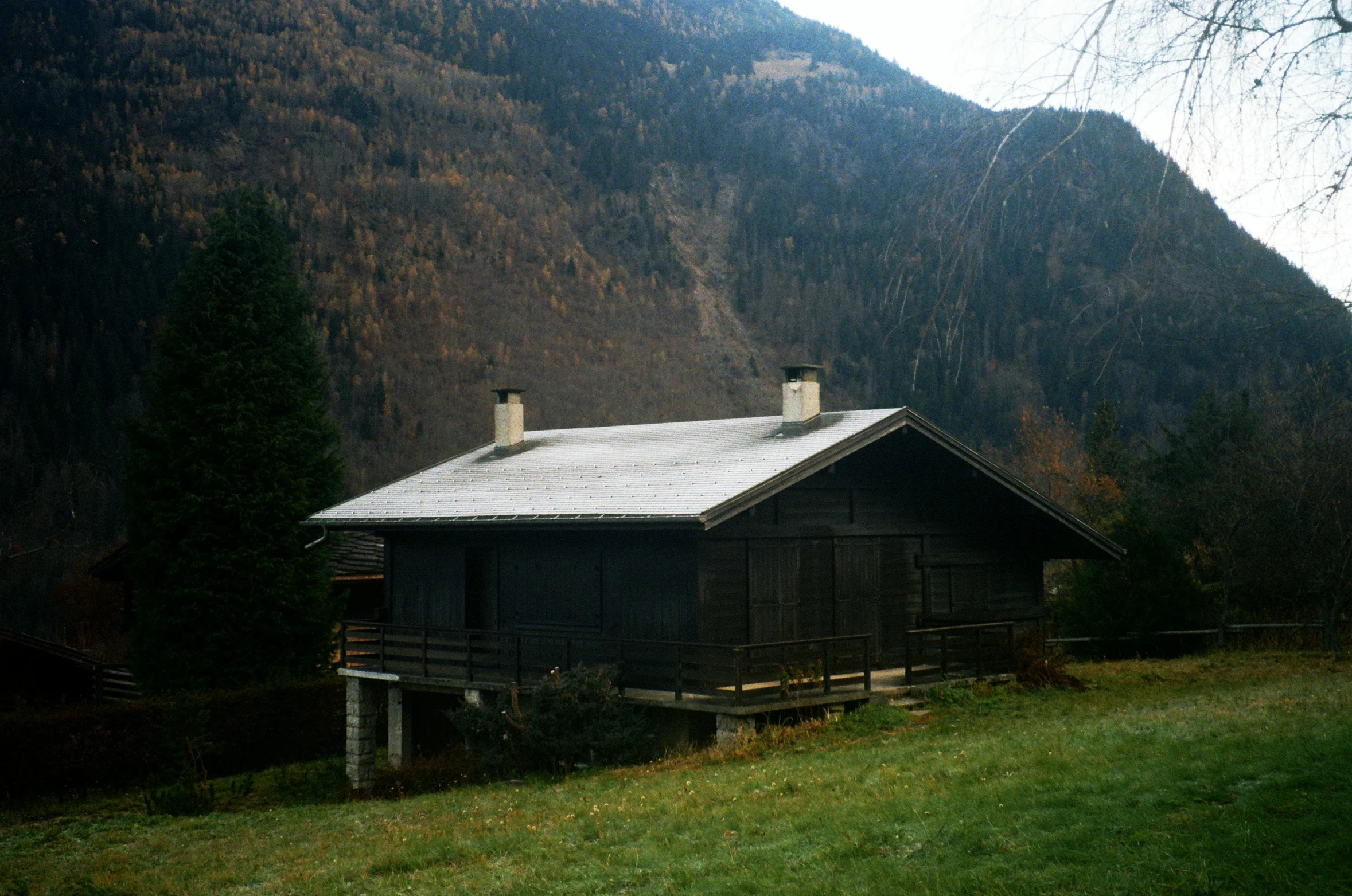 a small wooden building sitting next to a lush green hillside