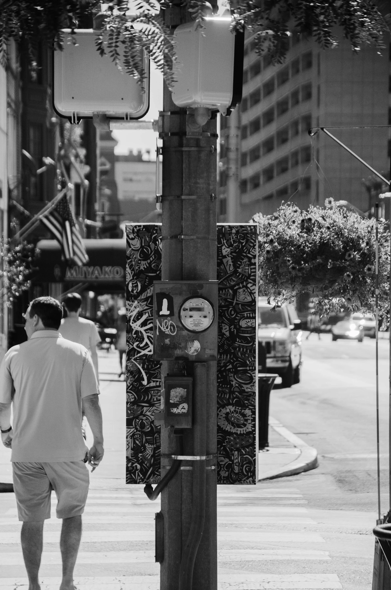 a man walking down a street under a traffic light