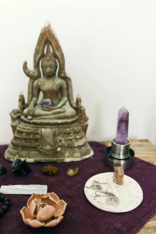 a table with several pieces of religious and buddha art