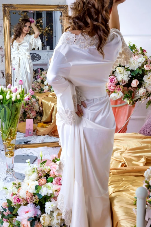 woman standing in front of mirror with flowers all around