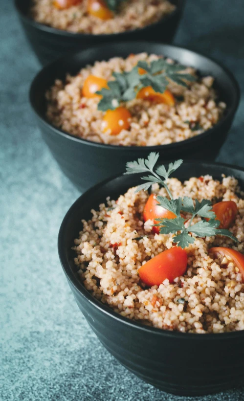 three small bowls of food that include carrots and rice